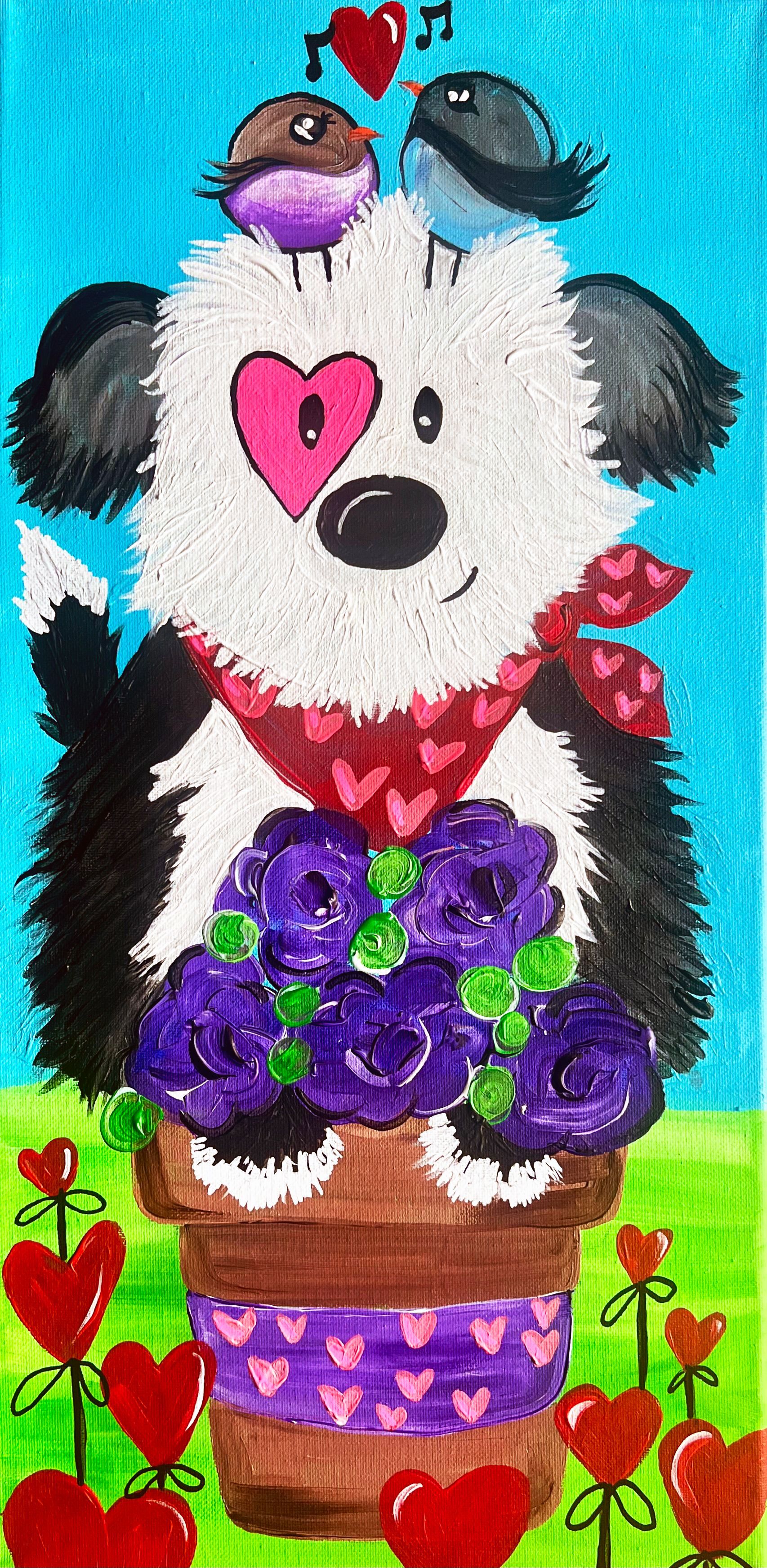 A black and white dog is sitting in a pot of purple flowers.
