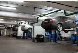 A car is sitting on a lift in a garage.