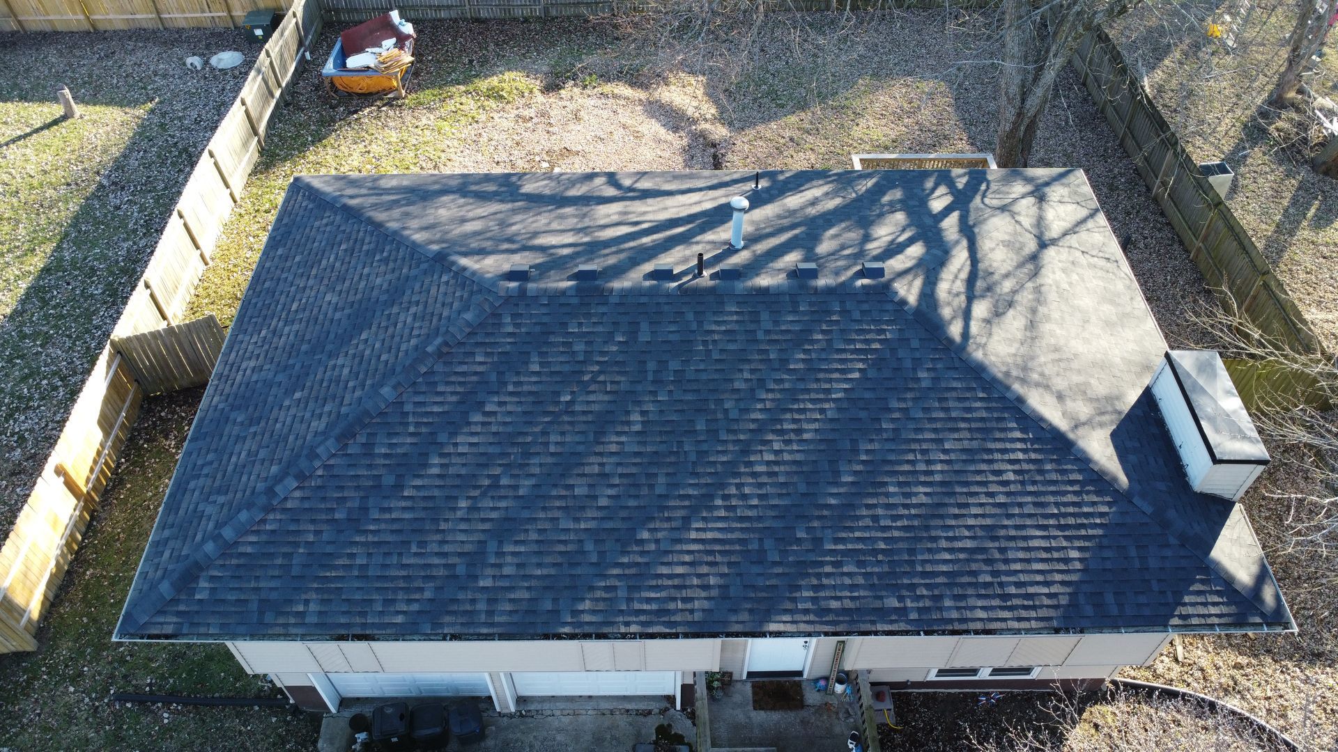 An aerial view of a house with a black roof.