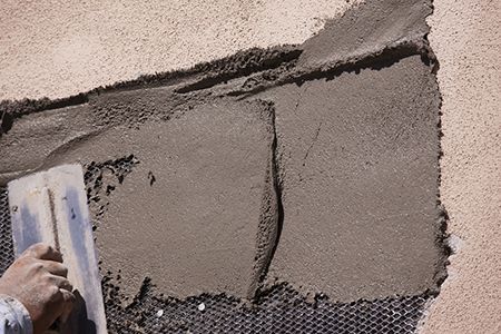 repair of a dark cream colour wall with stucco