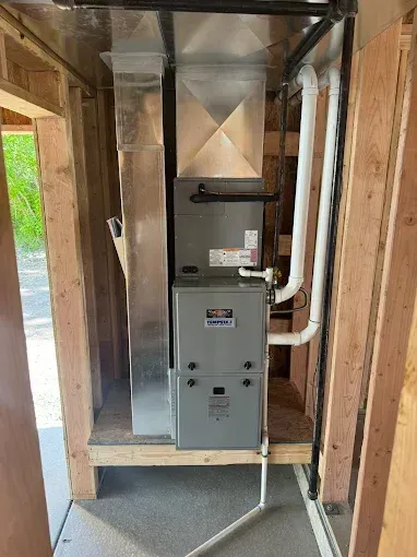 A furnace is installed in a room in a house under construction.