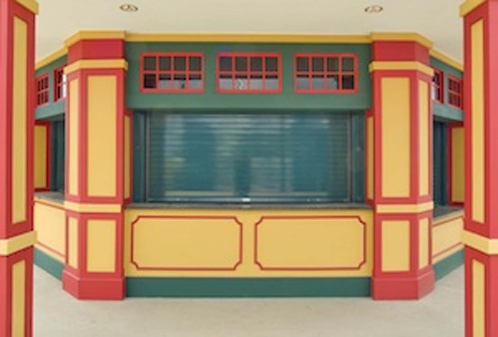 A red yellow and green building with a window