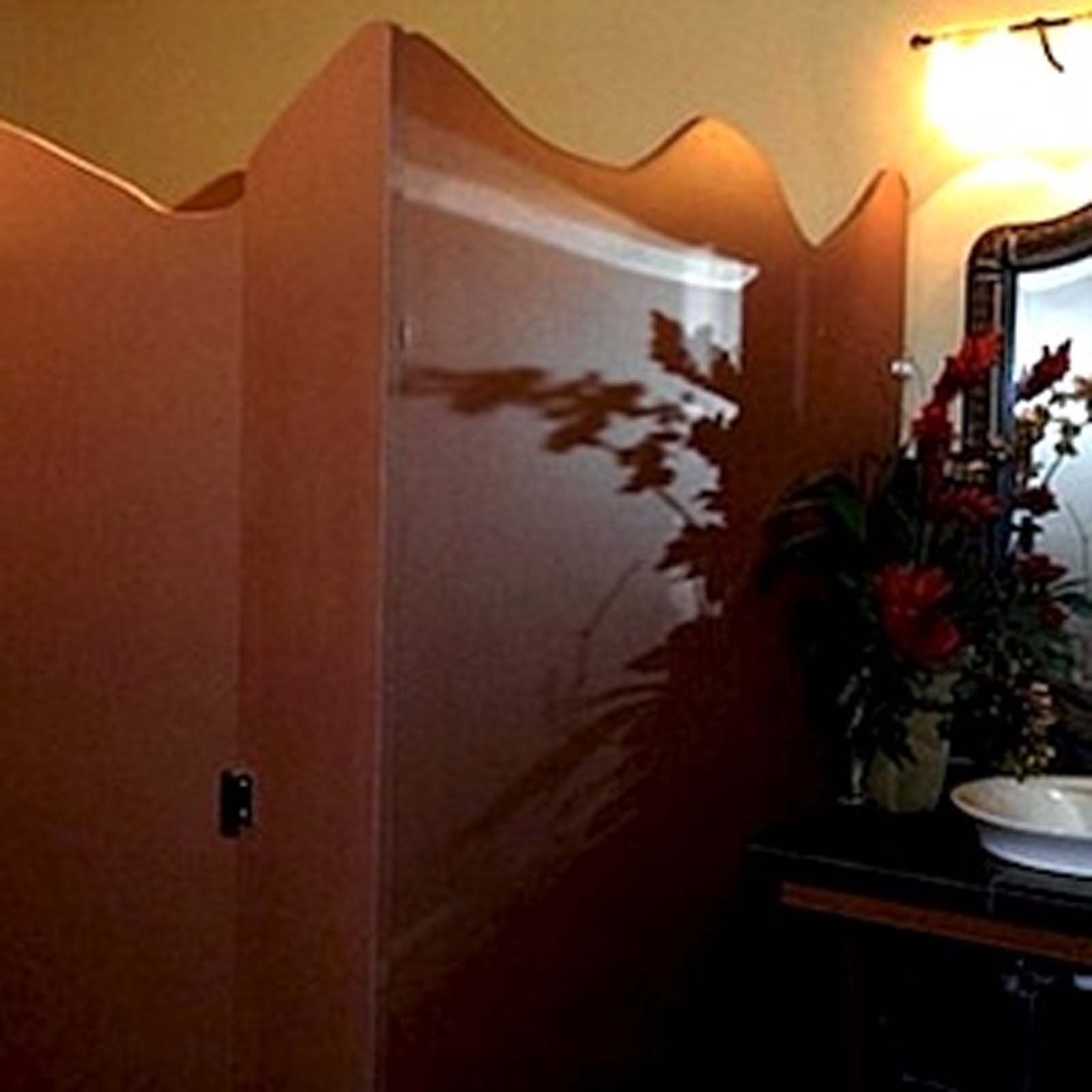 A bathroom with a mirror and flowers on the counter