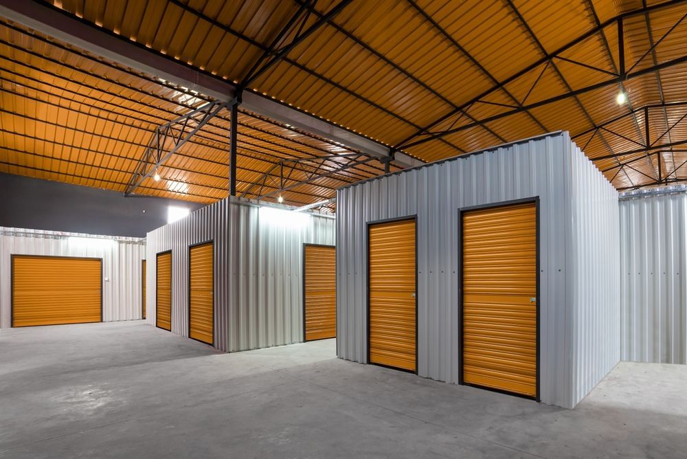 A large warehouse with a lot of storage units with orange doors.