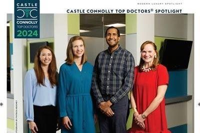 Group of four smiling people in a modern office, identified as Castle Connolly Top Doctors 2024.