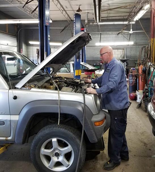Mechanic Under Car — Engine Repair in Allen Park, MI