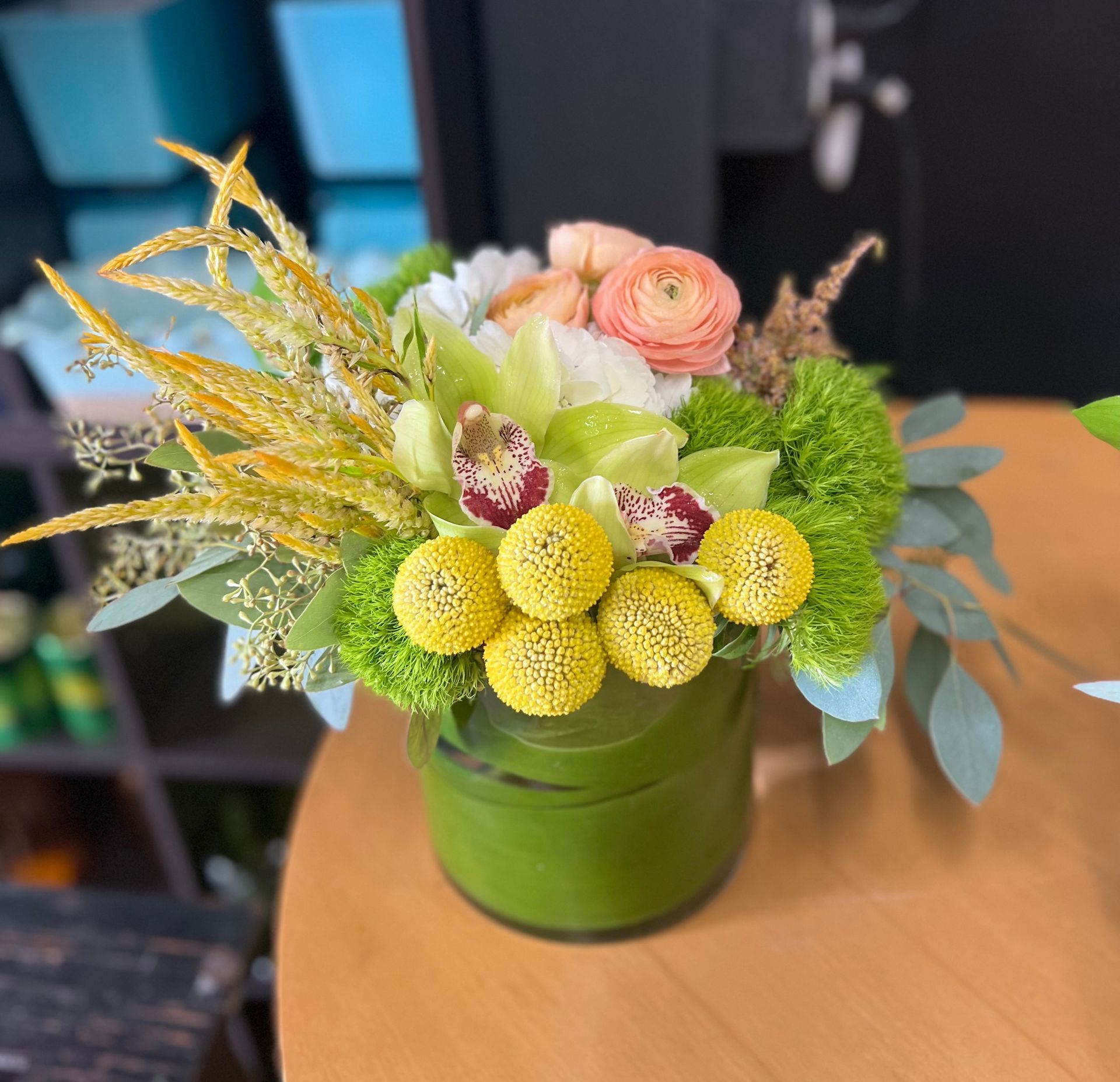 A vase filled with flowers is sitting on a wooden table.