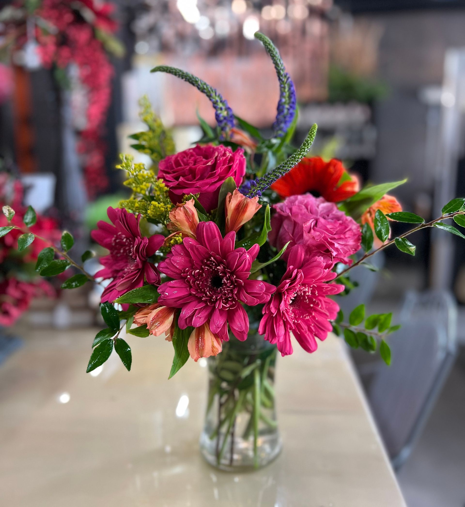 A vase filled with pink flowers is sitting on a table.