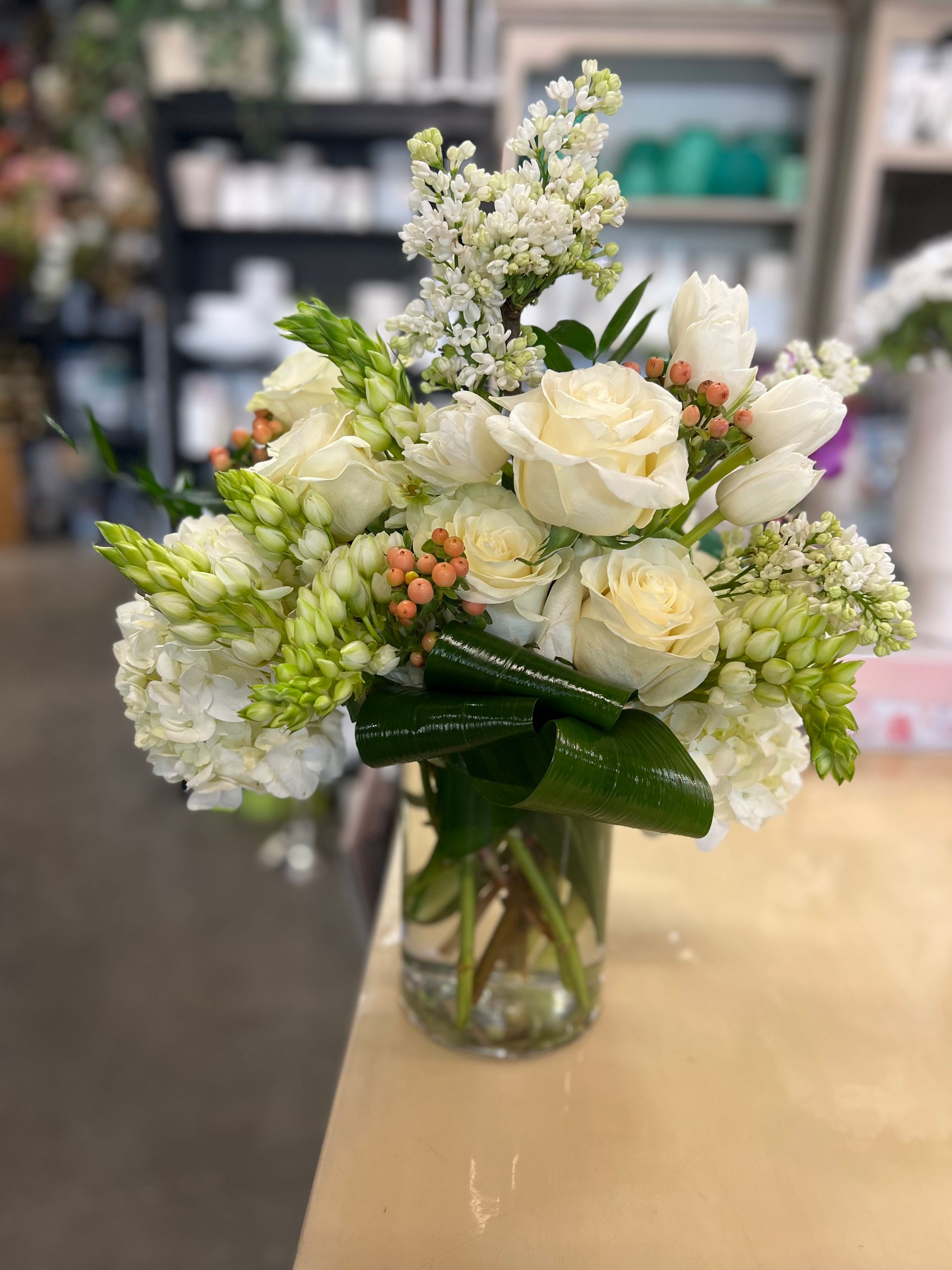 A vase filled with white flowers is sitting on a table.