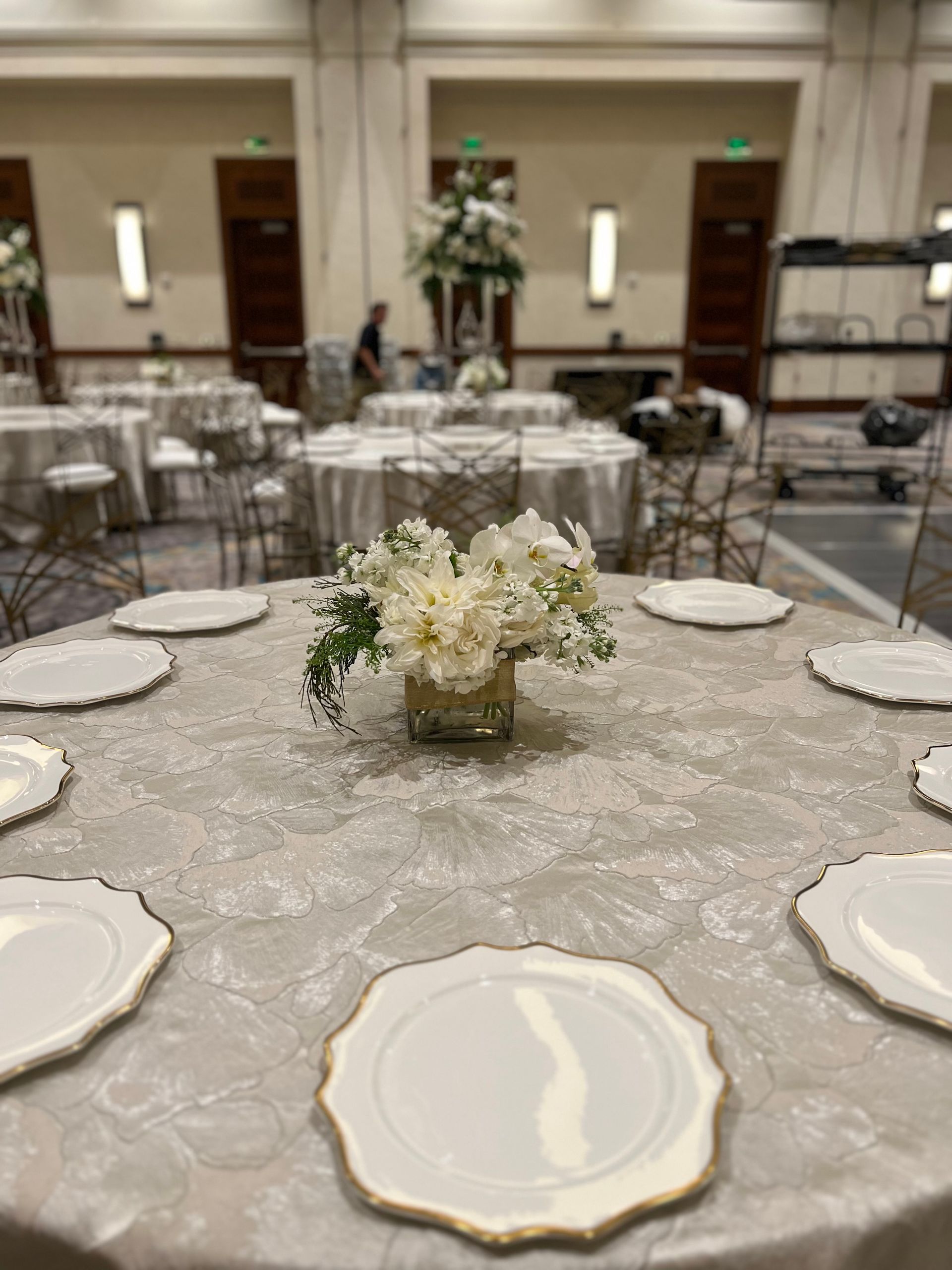A table with plates and a vase of flowers on it.