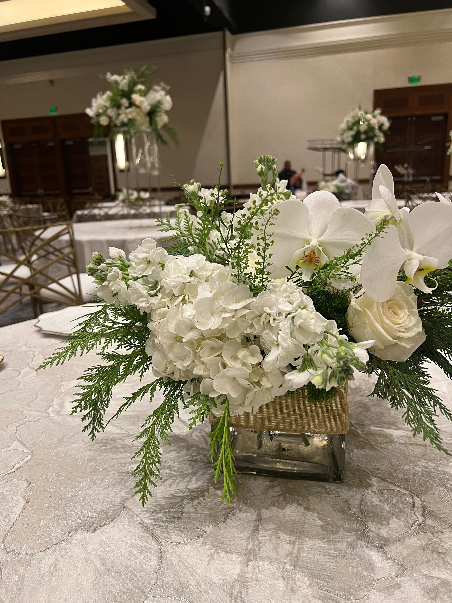 A vase filled with white flowers is sitting on a table.