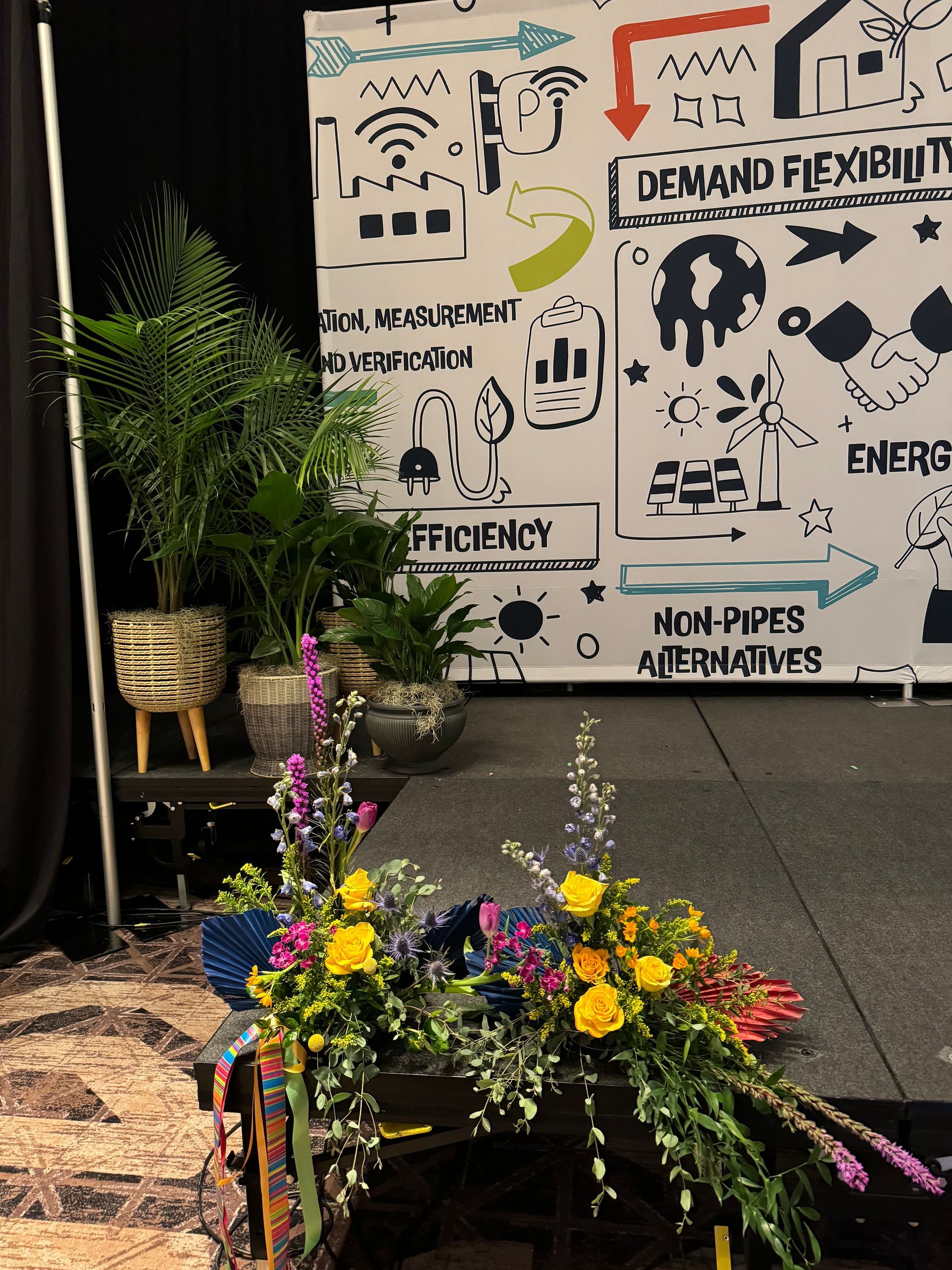 A stage with flowers in front of a sign that says demand flexibility