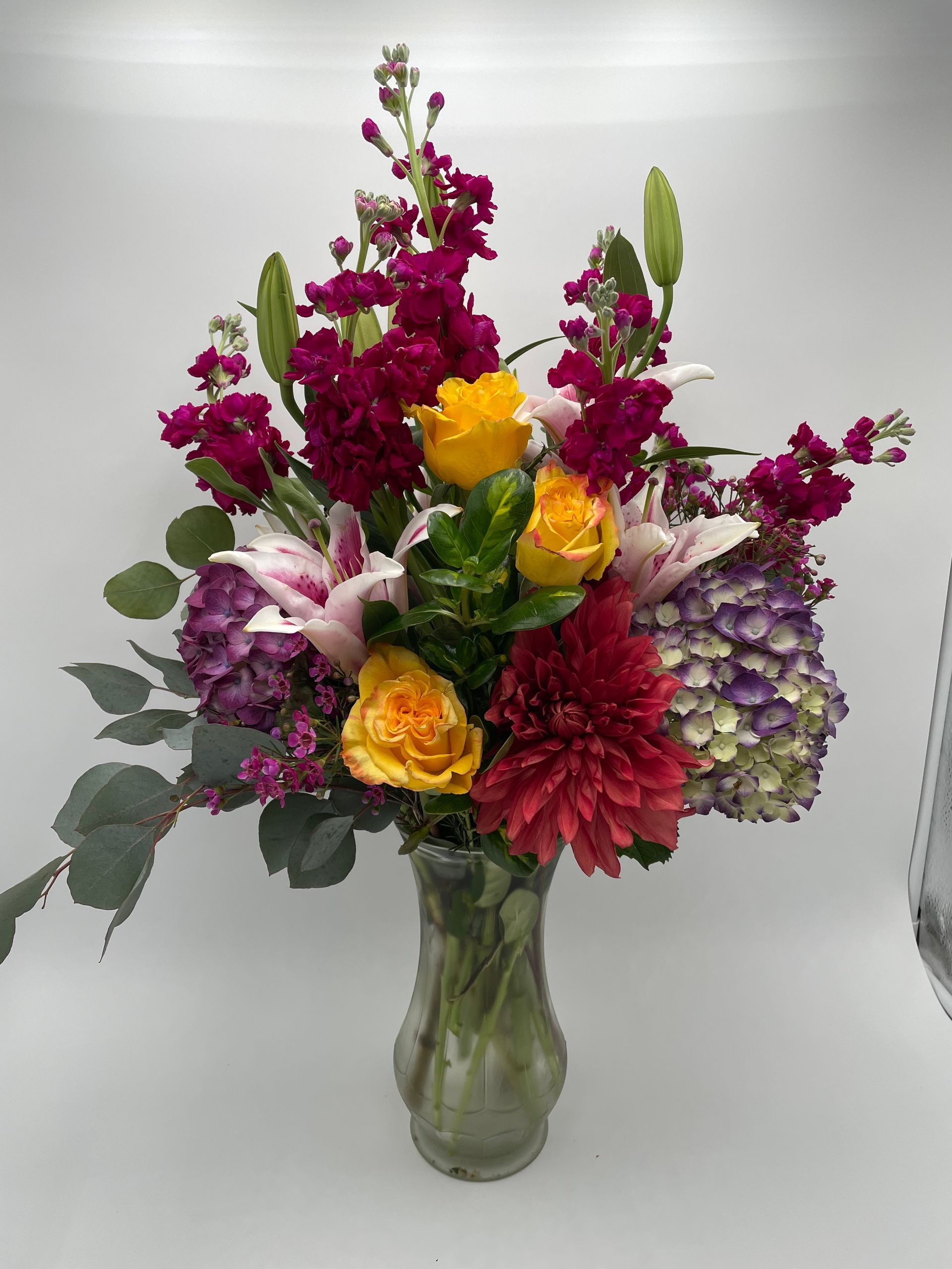 A vase filled with flowers on a white surface.
