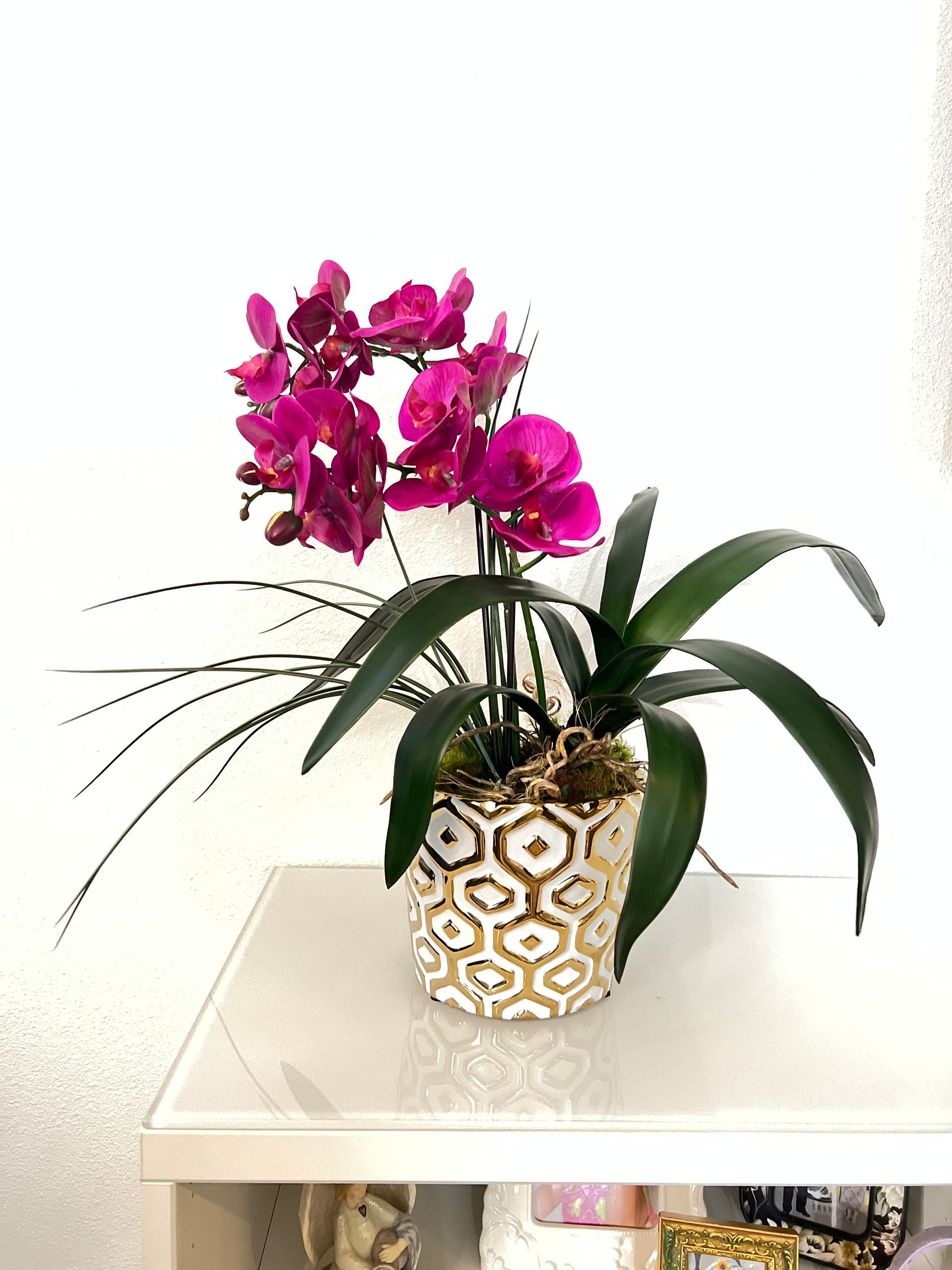 A potted plant with purple flowers is sitting on a table.