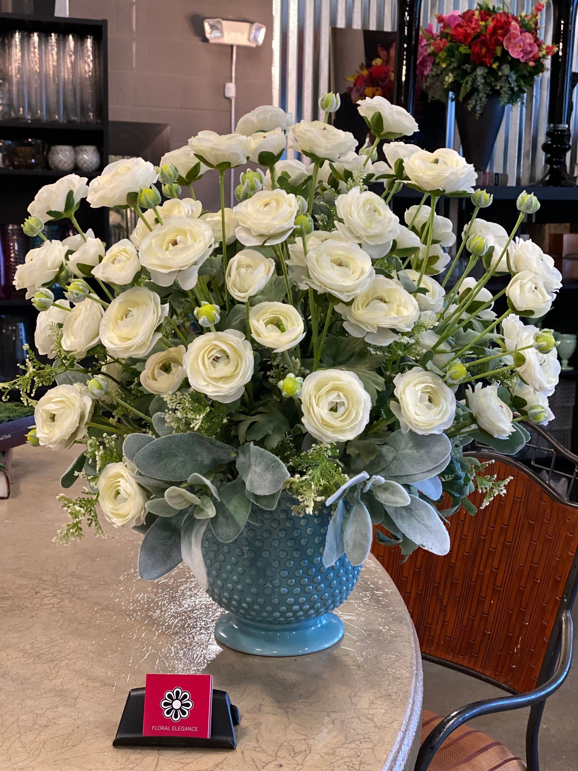A vase filled with white flowers is sitting on a table.