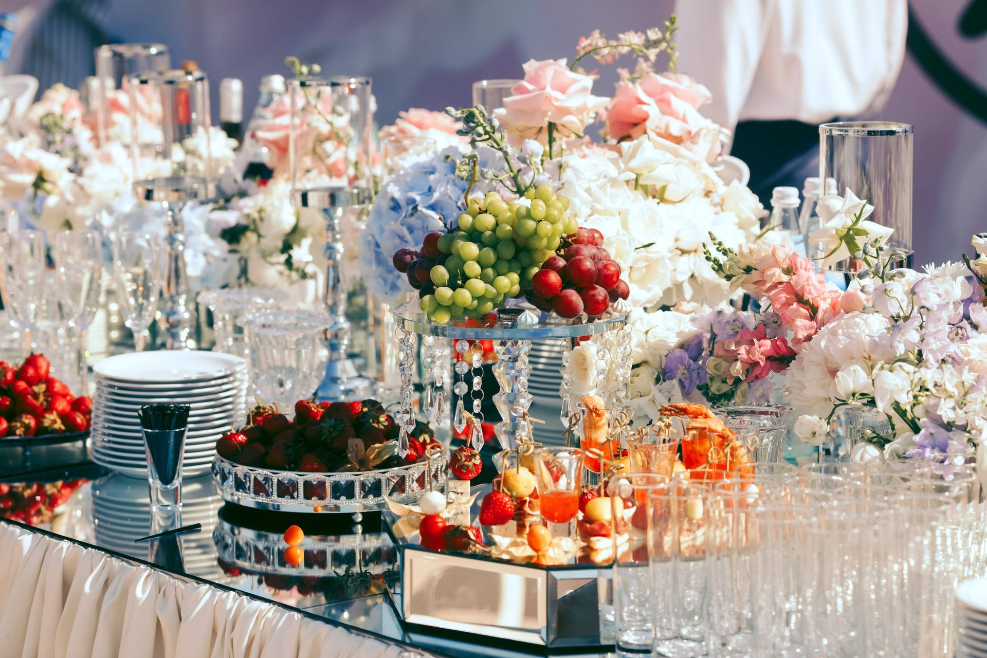 A long table with flowers and fruit on it.