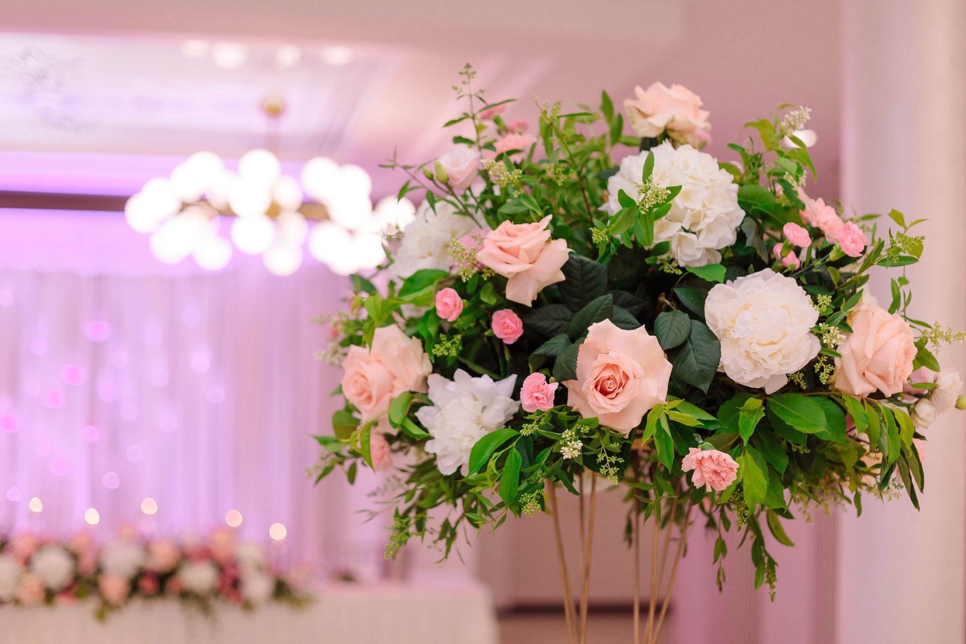 A vase filled with pink and white flowers in a room.