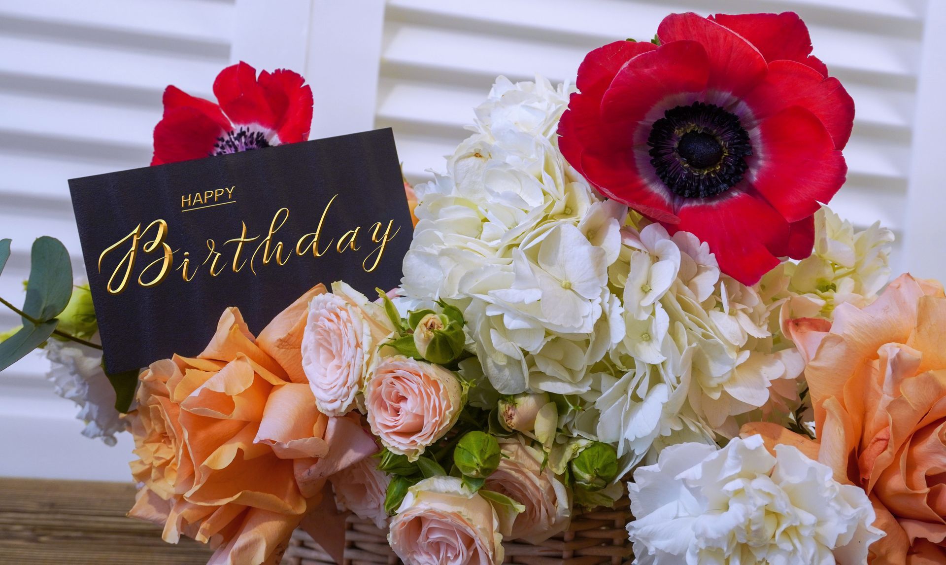 A coffin covered in flowers is sitting on a table.