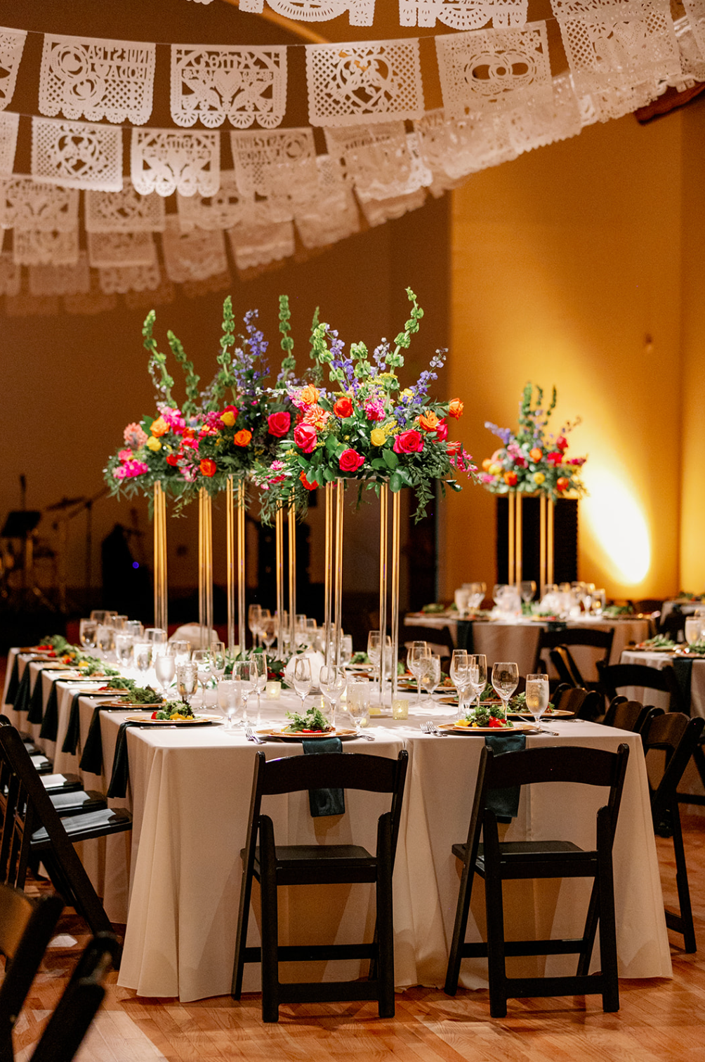 A table set for a wedding reception with flowers on it.