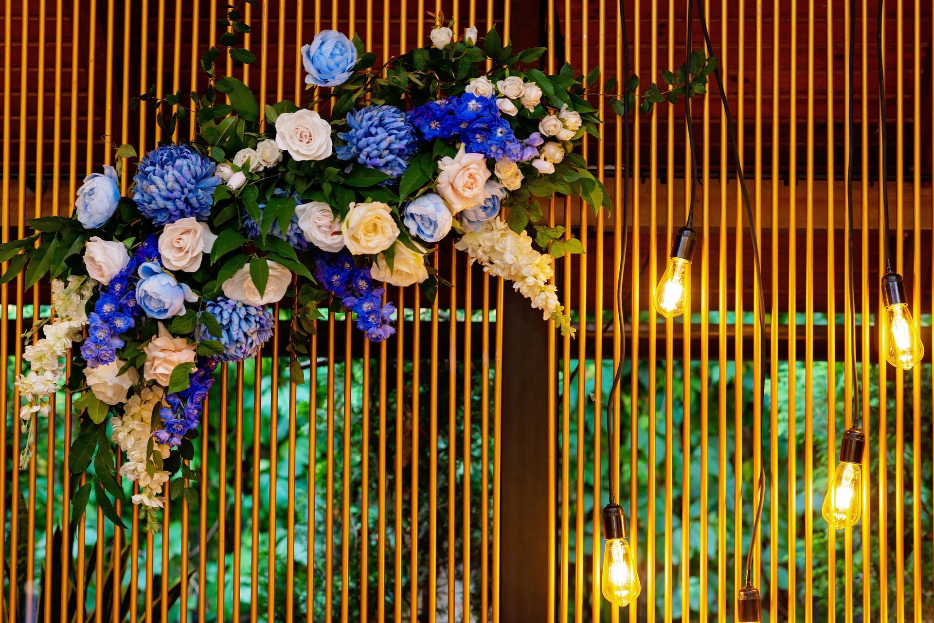 A wooden wall with flowers and lights hanging from it.