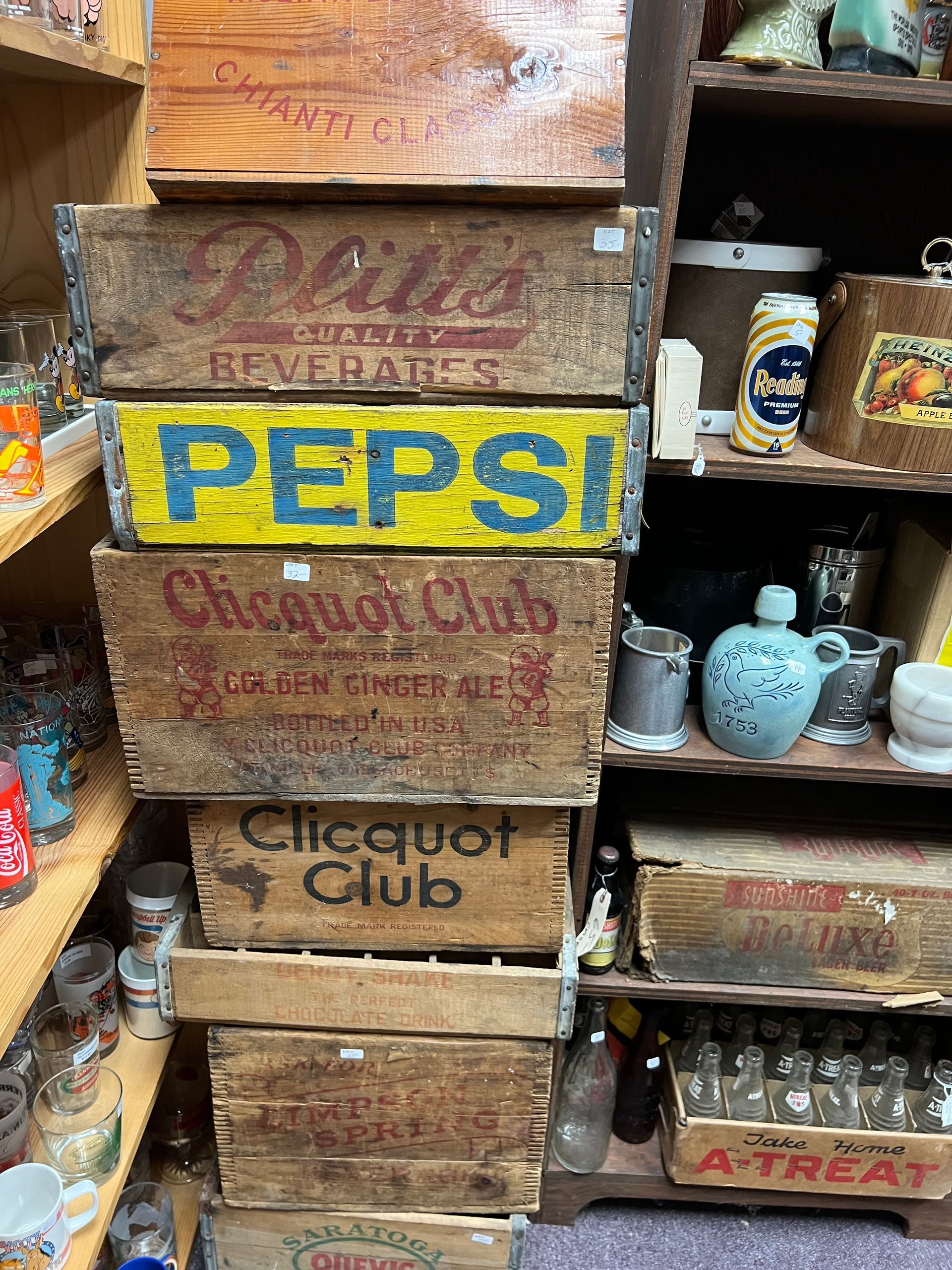 A stack of antique wooden crates with one that says pepsi on it