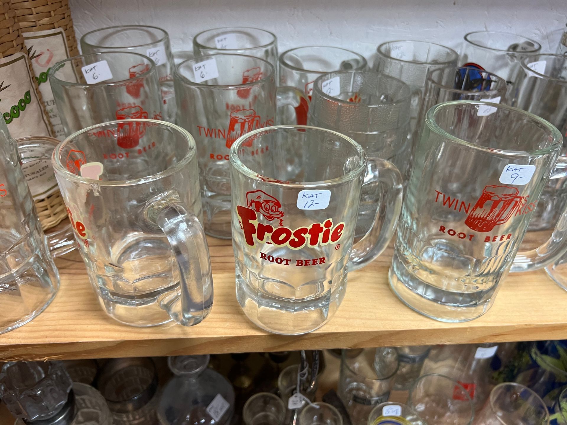 Several frostle mugs are on a wooden shelf