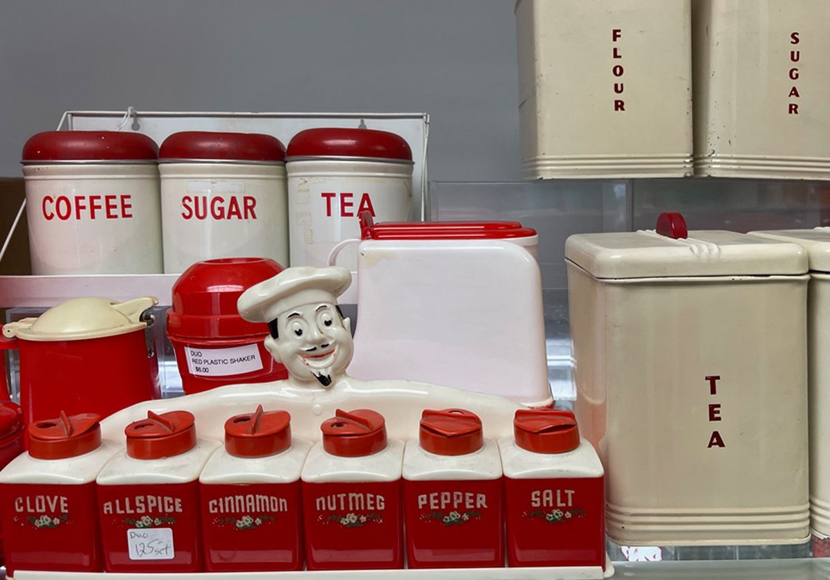 A display of red and white canisters including coffee sugar and tea