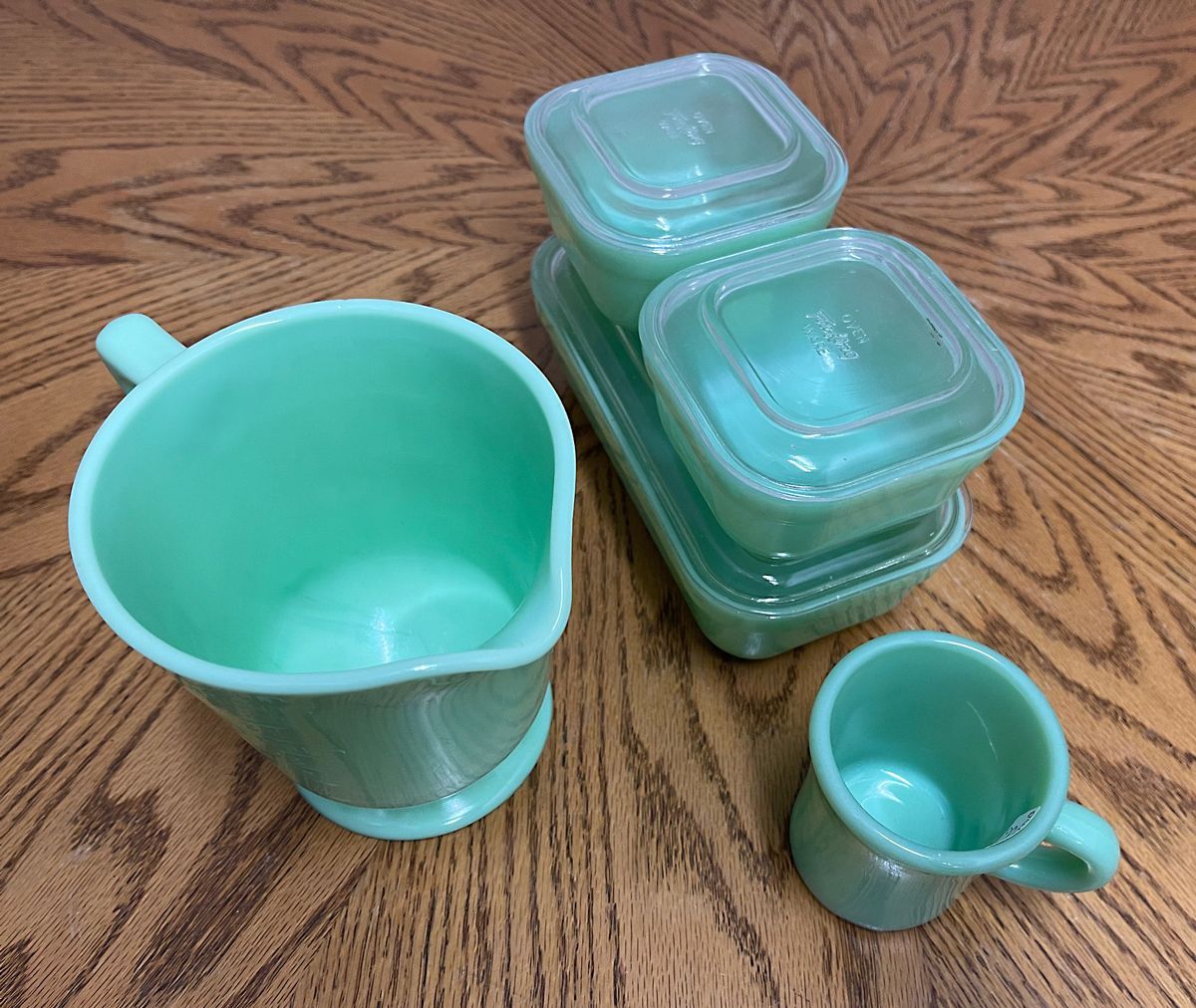 A stack of green cups and containers on a wooden table