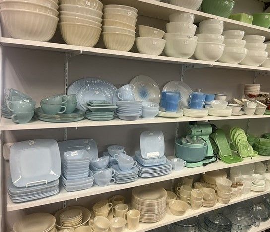 A shelf filled with lots of bowls , plates , and cups.