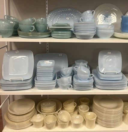A shelf filled with plates , bowls , cups and saucers.