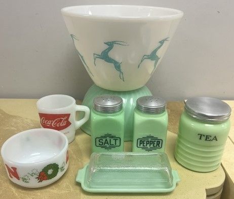 A table topped with a bowl , salt and pepper shakers , teapot , and butter dish.