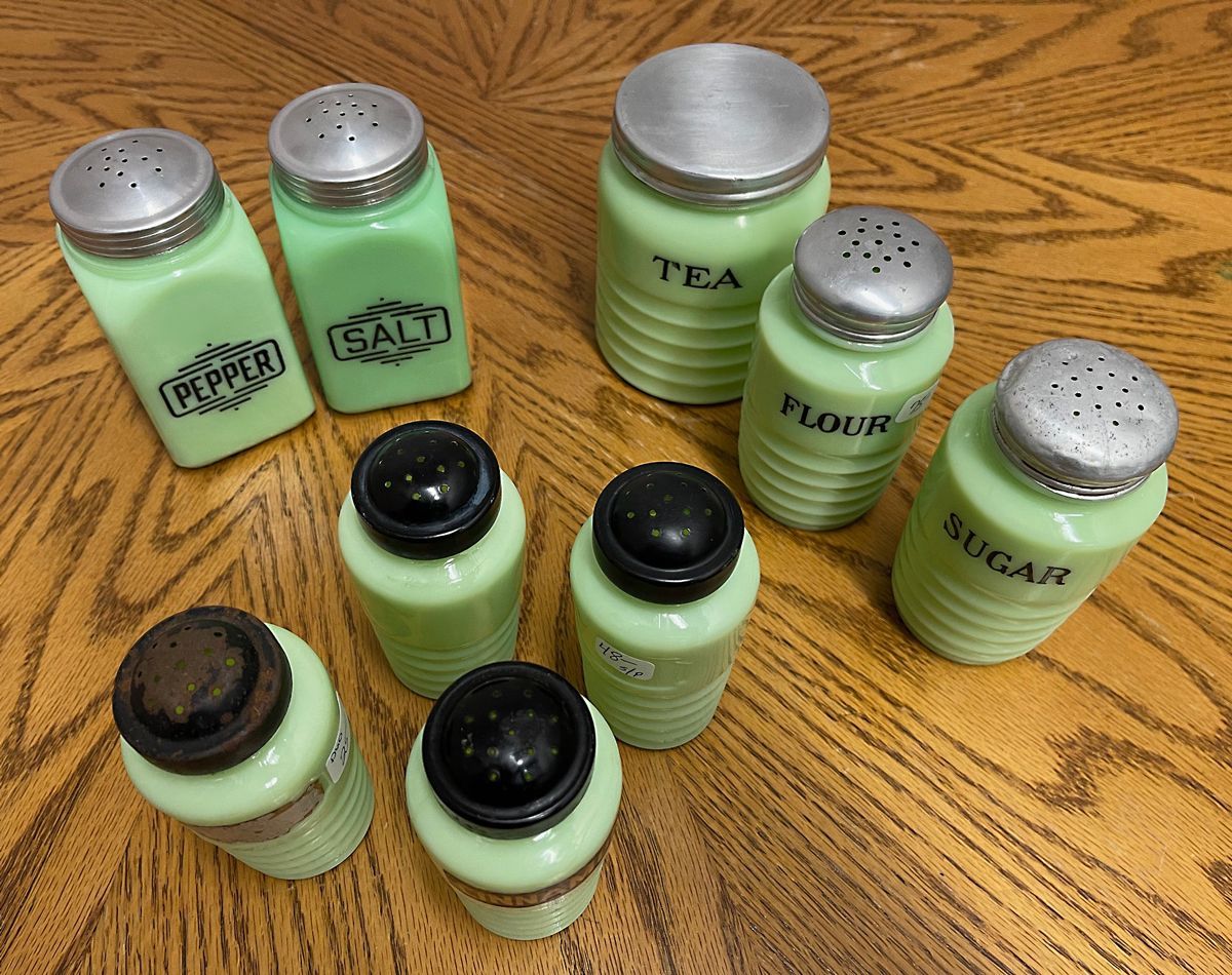 A group of green jars with the word tea on them