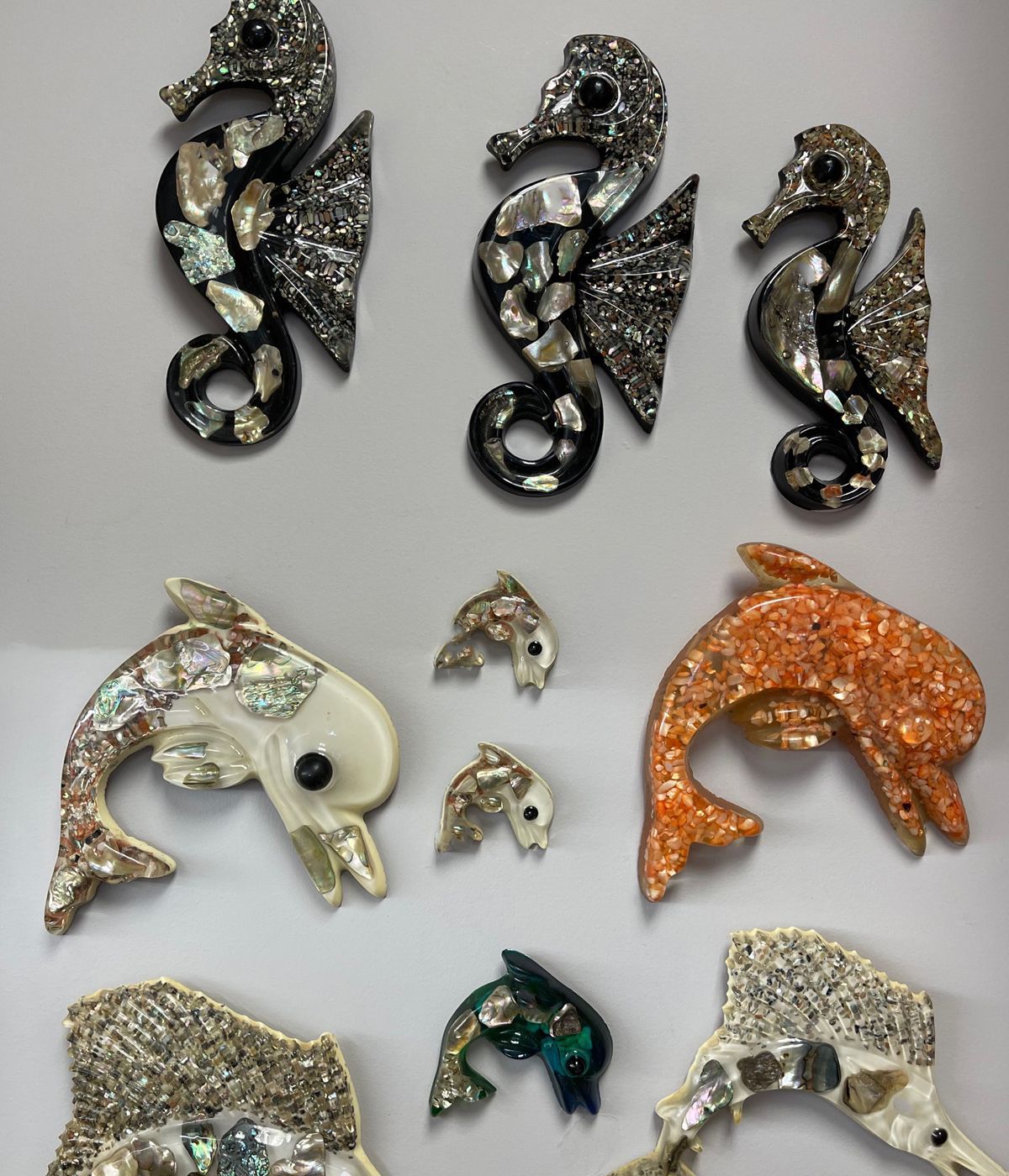 Several dolphins and seahorses are displayed on a white surface