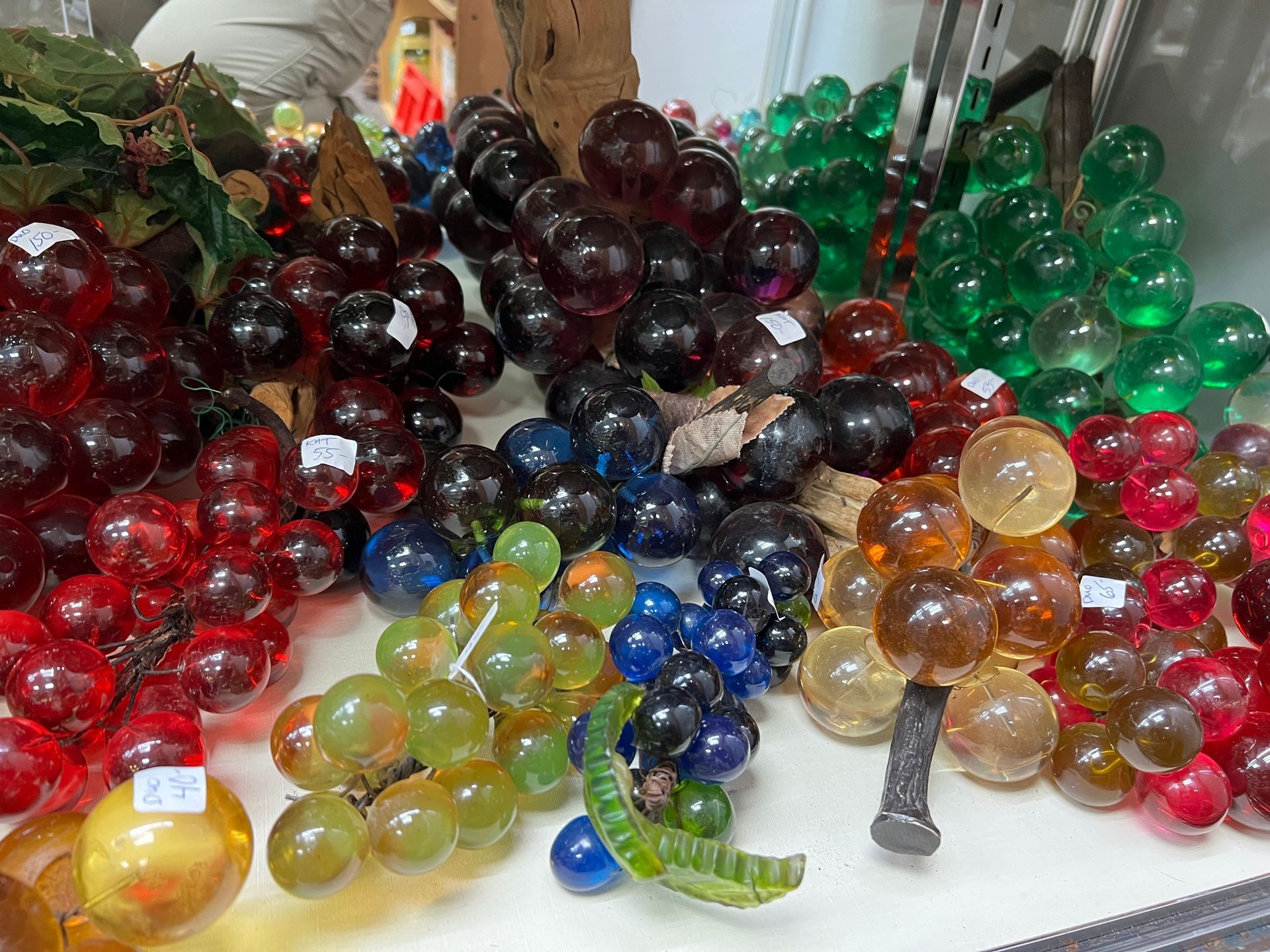 A bunch of different colored glass grapes on a table