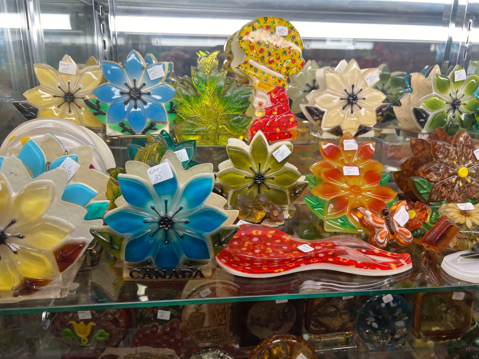 A glass display case filled with colorful glass flowers