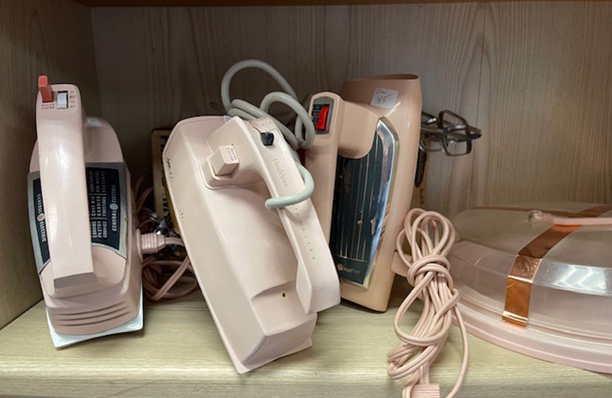 A shelf with a bunch of pink appliances on it