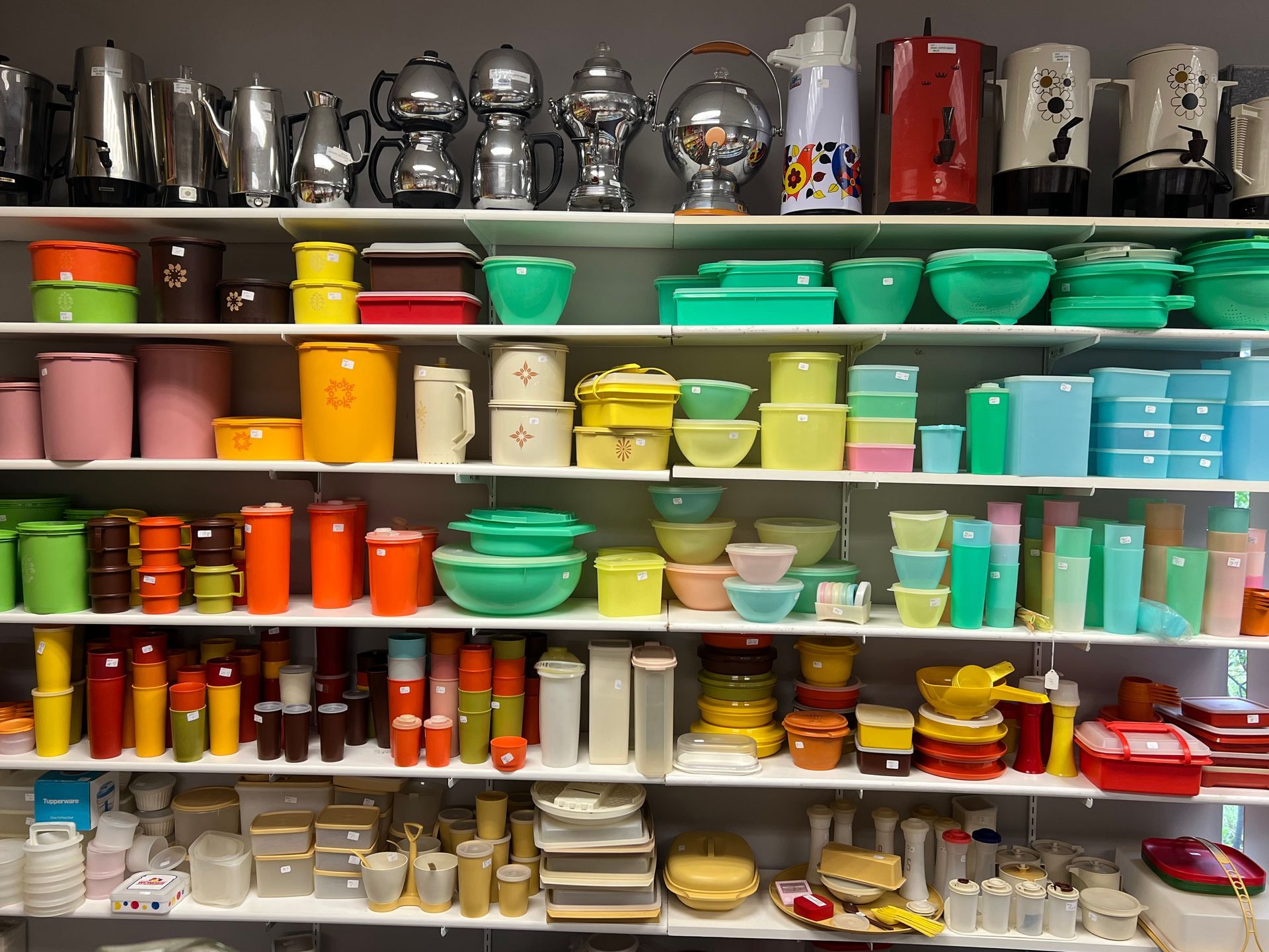 Shelves filled with a variety of colorful bowls and containers