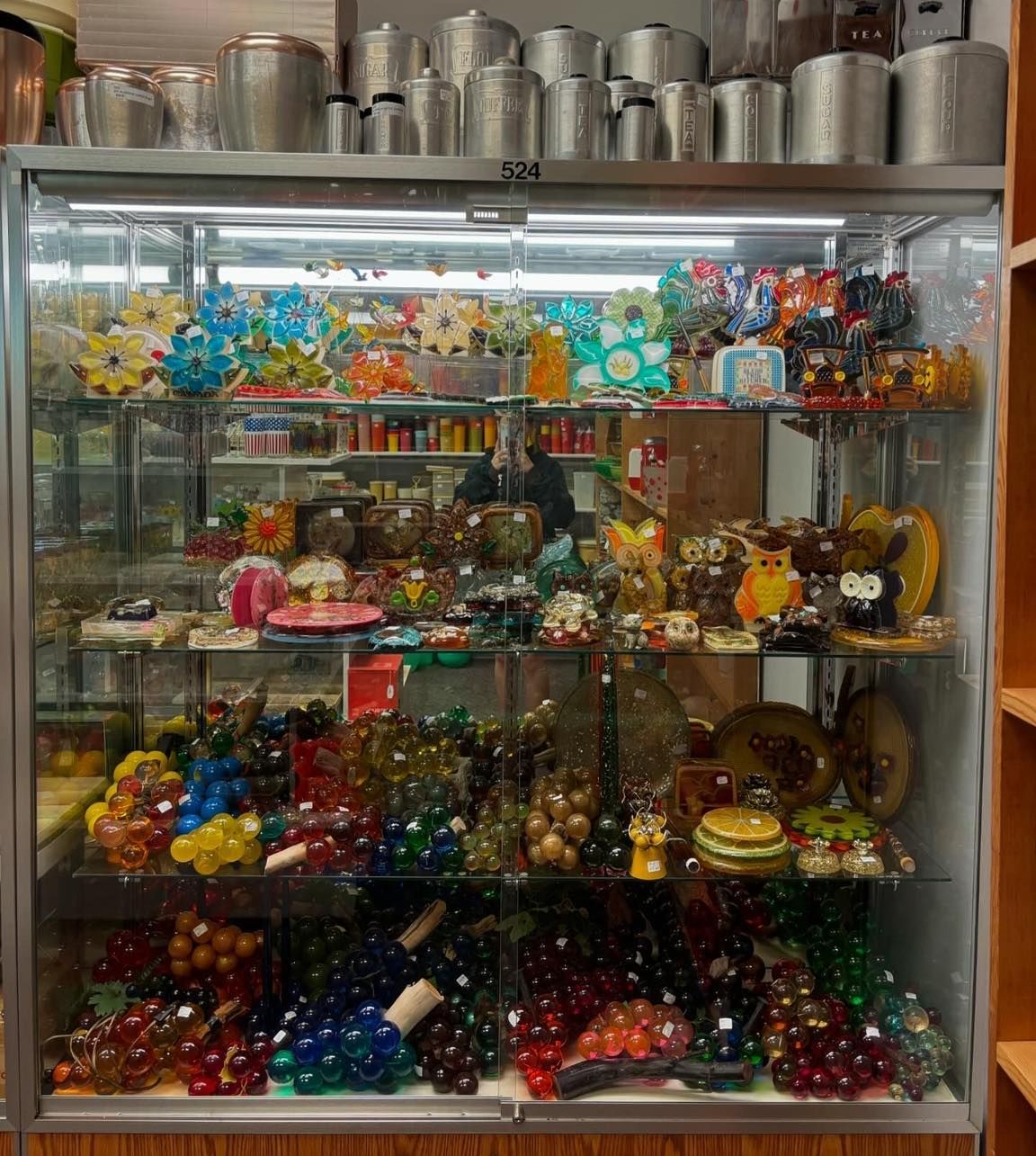 A glass display case filled with a variety of items