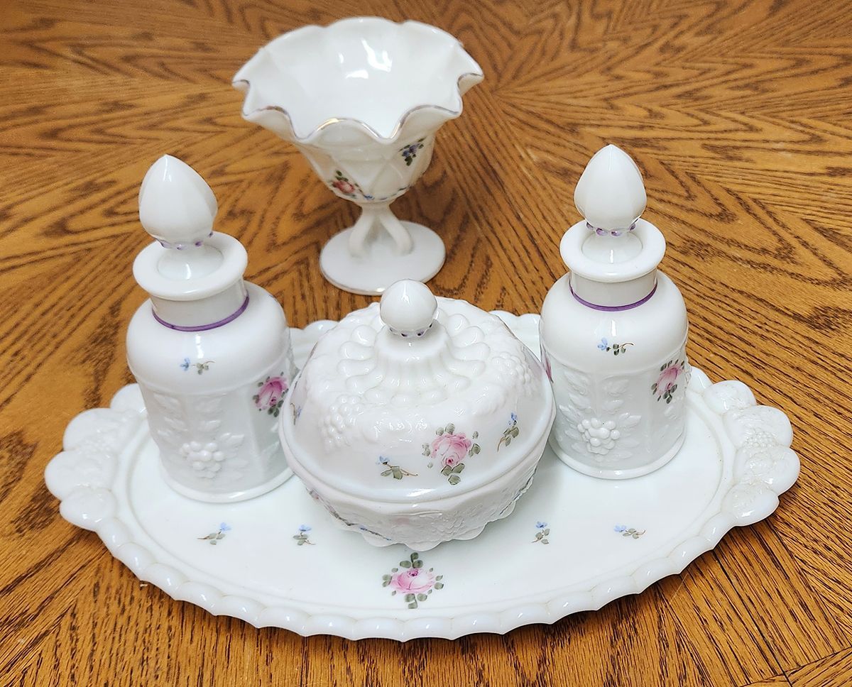 A white tray with three bottles and a bowl on it