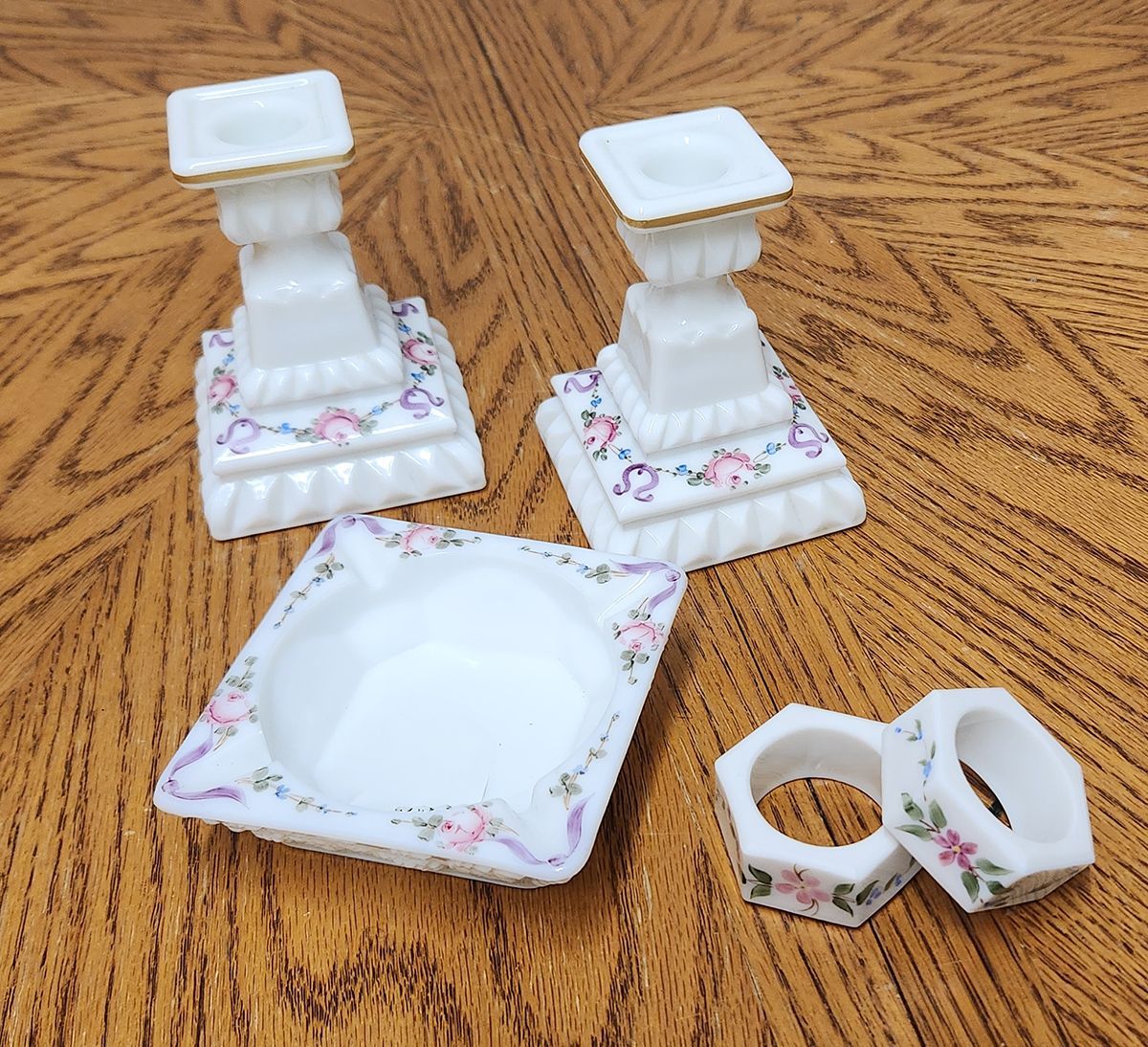 A set of candle holders and napkin rings on a wooden table