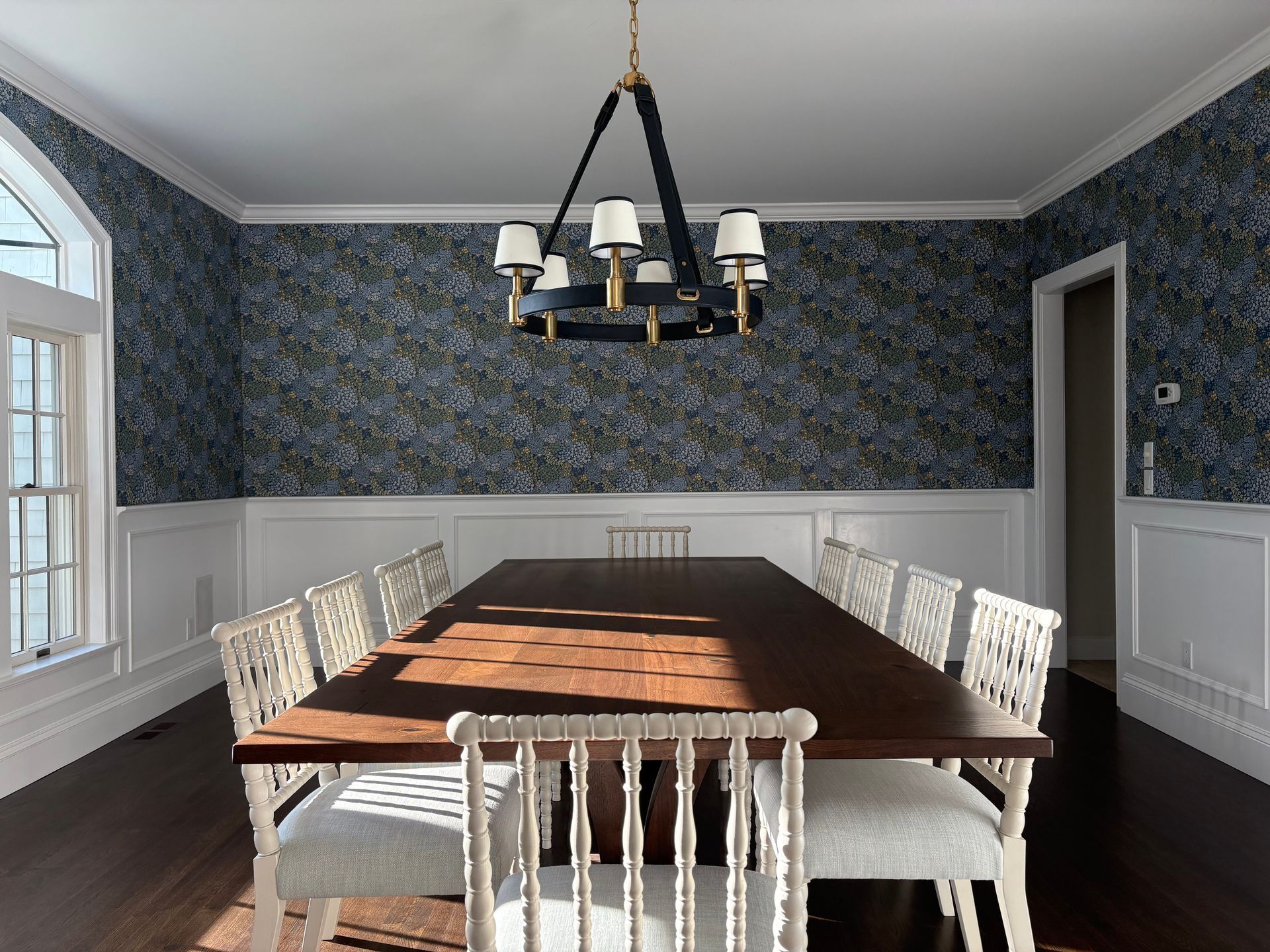 Patterned wallpaper and gold-accent chandelier.