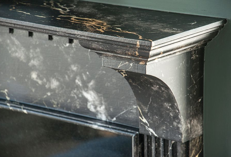 Marble fireplace with beveled edge and decorative corbel support.