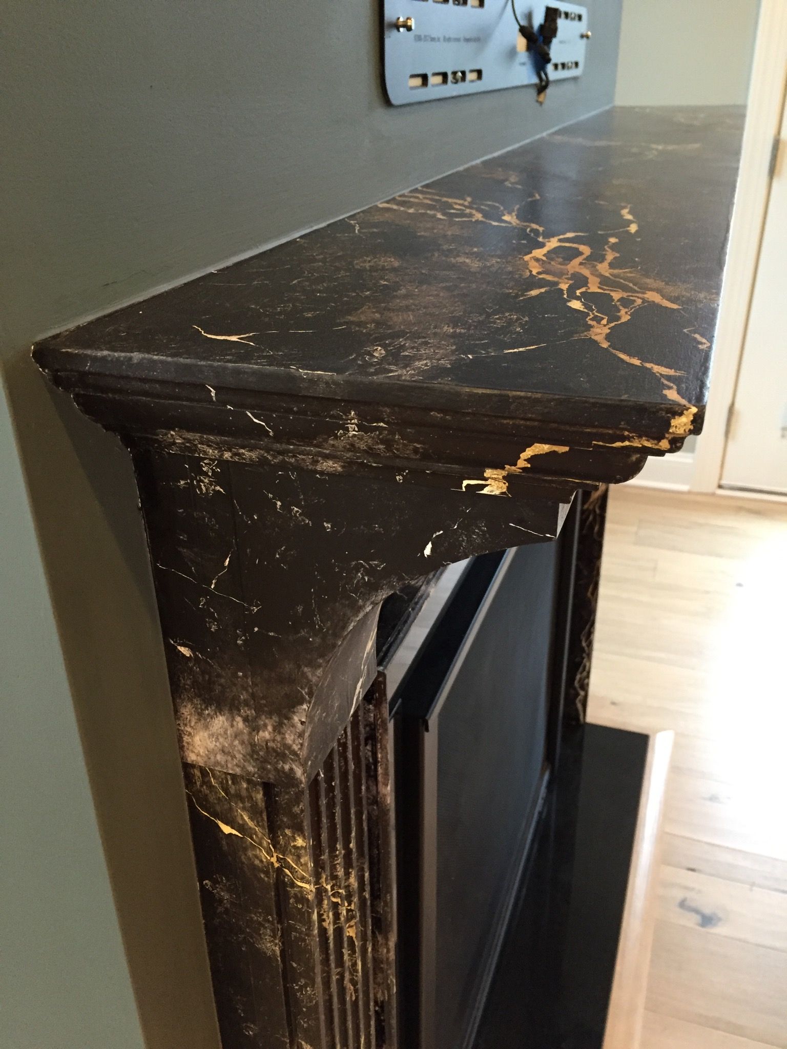 Fireplace with gold-veined marble and minimalist wall clock.