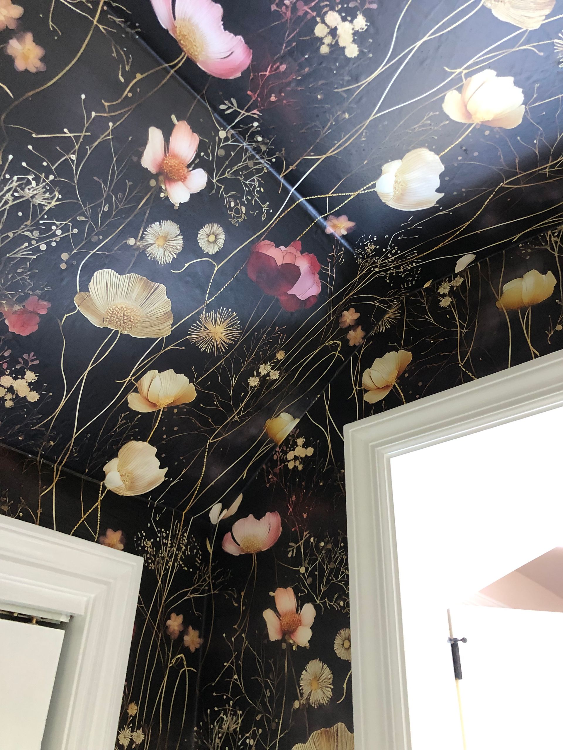 Dark floral wallpaper with pink blooms and gold branches.