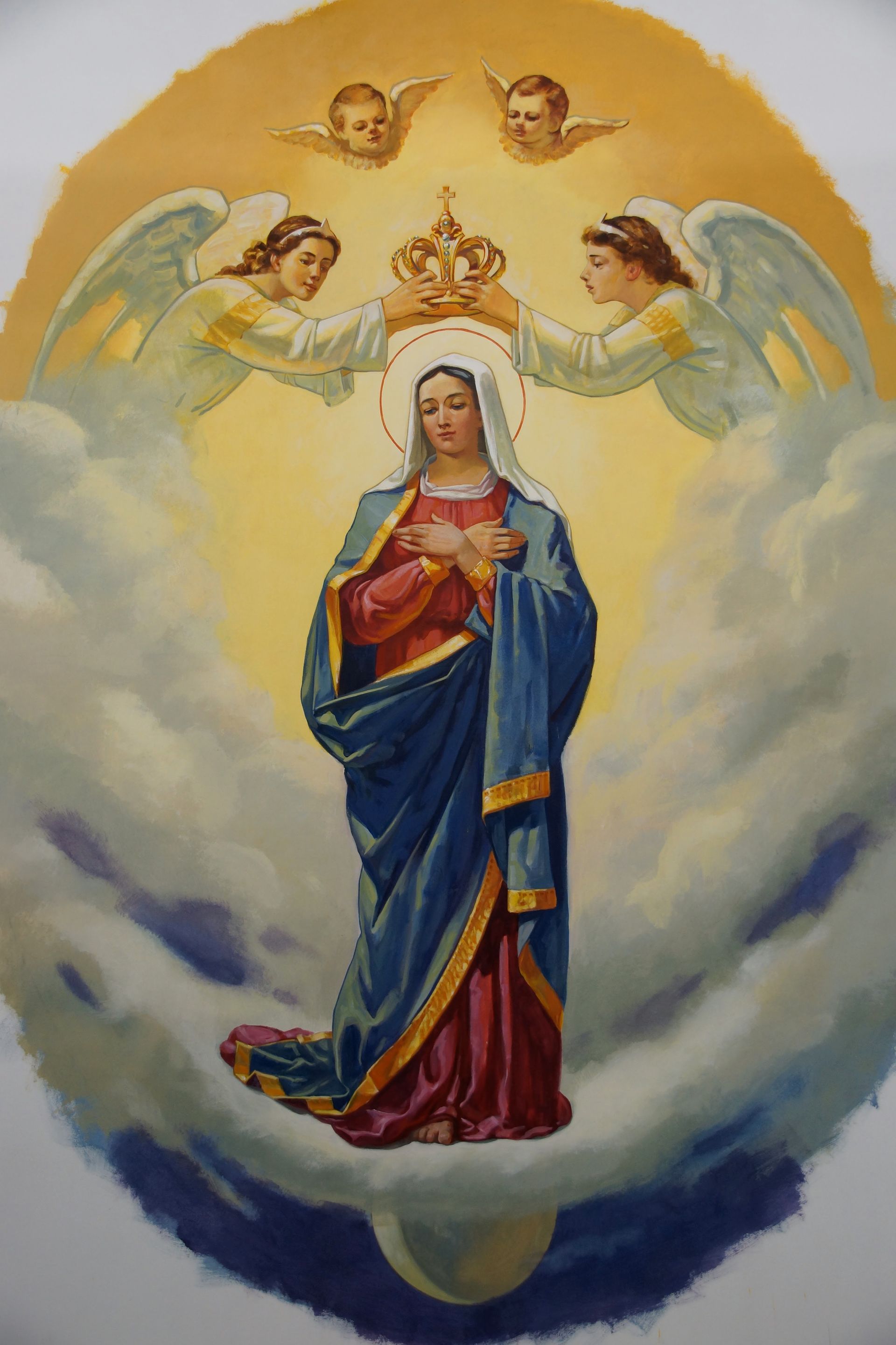 Mural of Virgin Mary crowned by angels, glowing golden light.