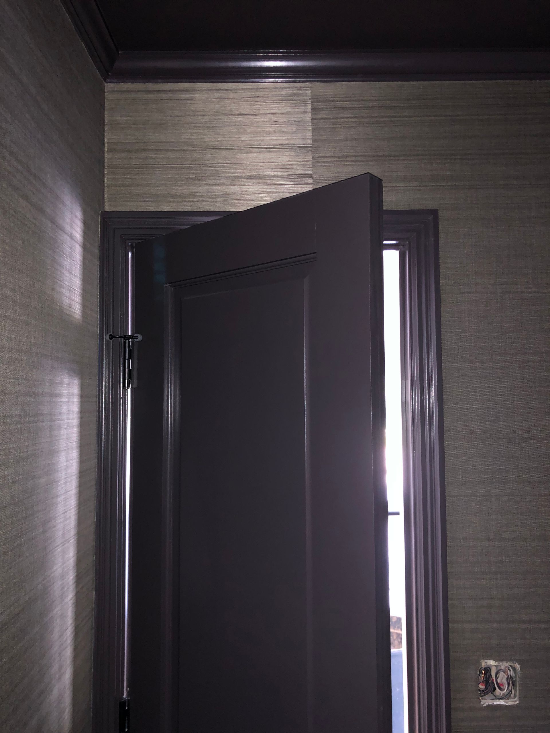 Horizontal textured wallpaper with dark door and ambient lighting.