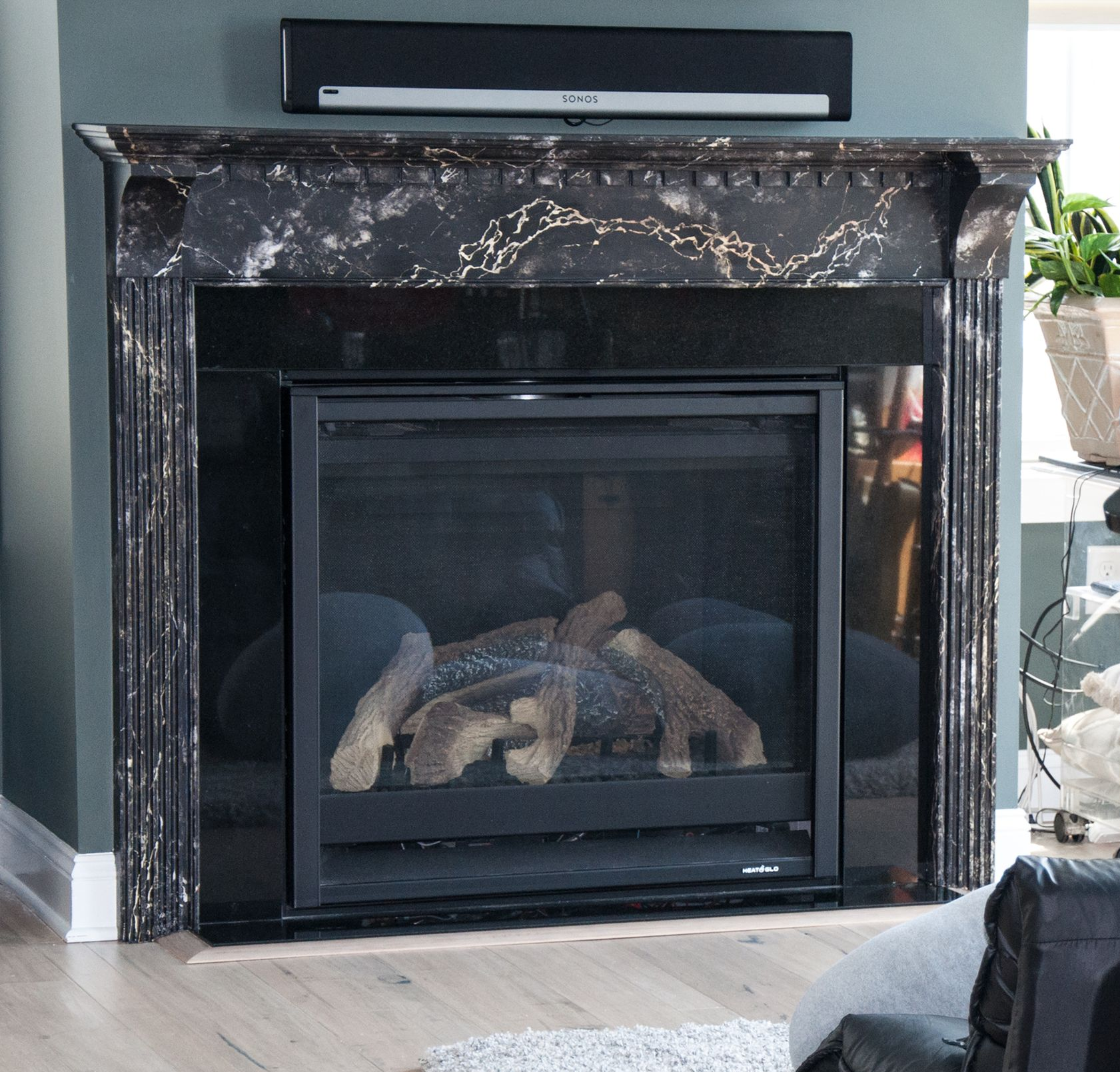 Modern fireplace with black marble and mounted soundbar.