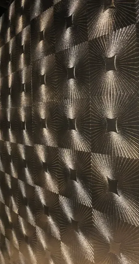 Textured wall tiles with metallic lines and optical depth.