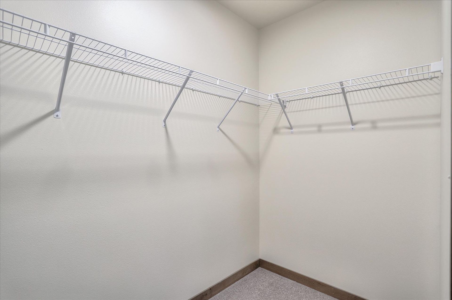 Empty white closet with wire shelving.