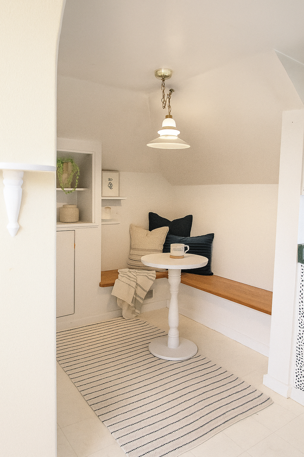 There is a table and a bench in the corner of the room.